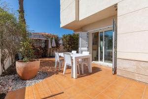 einen weißen Tisch und Stühle auf einer Terrasse in der Unterkunft Casa junto al mar con jardín in Sagunt