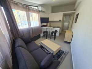 a living room with a couch and a kitchen at Beau Studio Hypercentre Saint Denis in Saint-Denis