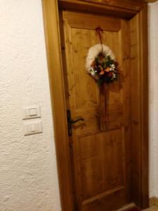 een houten deur met een krans erop bij APPARTAMENTO STELLA ALPINA in Cortina dʼAmpezzo