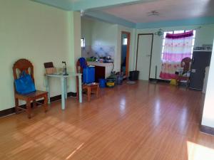 a living room with a wooden floor and a table at MJ TRANSIENT 5 in Baguio