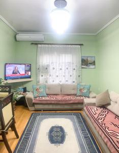 sala de estar con sofá y TV en Korca Central Flat, en Korçë