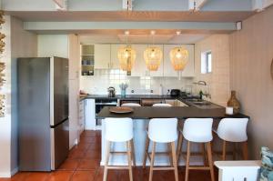 una cocina con encimera y taburetes blancos en Seehuisie Langebaan, en Langebaan 25 fotos más