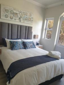 a bedroom with a large white bed with blue pillows at Caribbean Estates Villa Raiya- Recently Developed! 4 bedroom unit in Port Edward