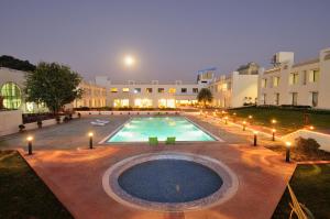una gran piscina con luces frente a un edificio en Inder Residency Resort & Spa Udaipur, en Udaipur