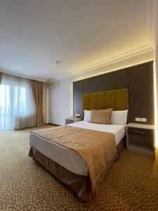 a bedroom with a large bed with a large headboard at SEFA HOTEL 1 ÇORLU in Çorlu