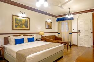 a hotel room with a bed and a chair at Citrus Chambers Mahabaleshwar in Mahabaleshwar