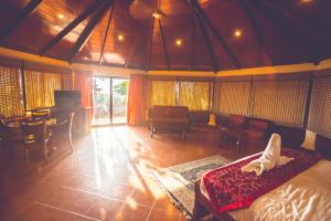 a bedroom with a bed and a table and chairs at Malpe Sea Front Cottages in Udupi