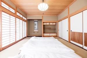 - une chambre avec un grand lit dans une pièce dotée de fenêtres dans l'établissement Yufu - House / Vacation STAY 77859, à Yufu