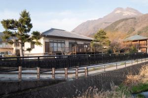 une maison au bord d'une rivière avec une montagne dans l'établissement Yufu - House / Vacation STAY 77859, à Yufu
