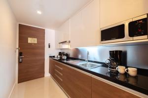 a kitchen with a sink and a counter top at Oakwood Residence Sukhumvit 24 - SHA Extra Plus in Bangkok