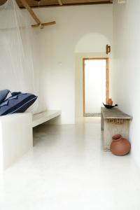 a white room with a bed and a table at The Oasis Villa in Ahangama