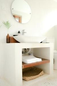 a white bathroom with a sink and a mirror at The Oasis Villa in Ahangama