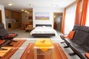 a bedroom with a bed and two chairs and a table at Garden Apartments Janša in Radovljica