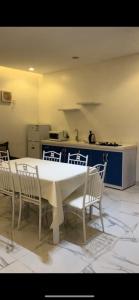 Altaraf Resort في الشفا: مطبخ مع طاولة بيضاء وكراسي في غرفة