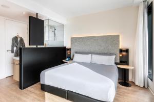 a bedroom with a large bed and a table at INNSiDE by Meliá Amsterdam in Amsterdam