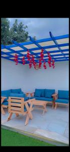 a group of chairs and tables with red flowers at Altaraf Resort in Al Shafa