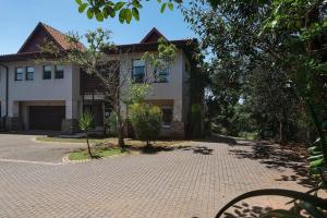 uma casa com uma entrada de tijolos em frente em 9 On Crystal Cove 5 Bedroom Townhouse in Zimbali em Ballito