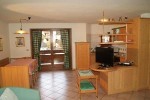 a living room with a desk with a computer on it at Residence Margherita in Moena