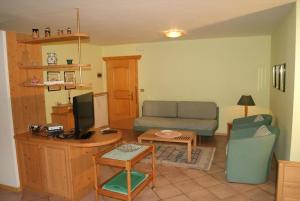 a living room with a couch and a television at Residence Margherita in Moena