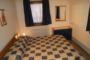 una camera con un letto con una coperta a scacchi di Residence Margherita a Moena