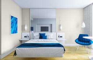 a bedroom with a bed and a blue chair at Batumi Inn Aparthotel With Sea View in Batumi