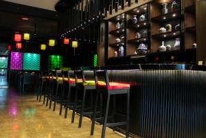 a row of stools in a bar in a restaurant at Ashley Tang Menteng Jakarta in Jakarta