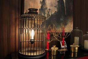 a bird cage with a light on top of a table at Ashley Tang Menteng Jakarta in Jakarta