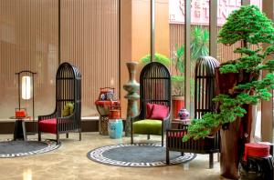 ジャカルタにあるAshley Tang Menteng Jakartaの椅子2脚と木が並ぶ部屋