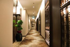 a hallway of a hotel with a potted plant at Ashley Tang Menteng Jakarta in Jakarta
