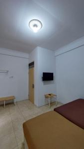 a bedroom with a bed and a tv on a wall at Al Barra Syariah Hotel in Bukittinggi