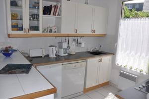 a kitchen with white cabinets and a counter top at Maison VUE MER de plain-pied avec WIFI à PLEUMEUR - BODOU REF-649 in Pleumeur-Bodou