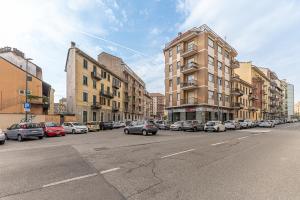 une rue de la ville avec des voitures garées sur le côté de la route dans l'établissement CASA SAN PAOLO, à Turin