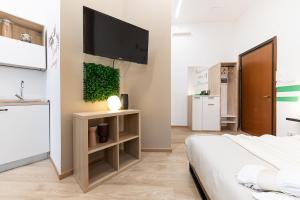 une chambre avec un lit et une télévision sur un mur dans l'établissement CASA SAN PAOLO, à Turin