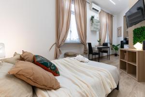une chambre avec un lit, un bureau et une télévision dans l'établissement CASA SAN PAOLO, à Turin