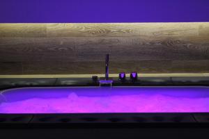 a purple bath tub with purple lighting in a room at Le casette in Monopoli