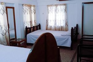 a bedroom with two beds and a mirror at Ashiana Serviced Apartment in Sylhet