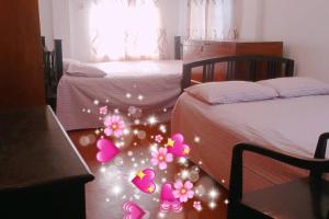 a bedroom with two beds and pink christmas decorations at Ashiana Serviced Apartment in Sylhet