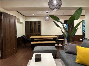 札幌市にあるLIT’S INN Sapporoのソファとテーブルのあるリビングルーム