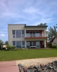 une grande maison avec une pelouse devant elle dans l'établissement Villa Balaton Beach Boglár, à Balatonboglár