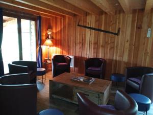 une salle d'attente avec des chaises et un mur en bois dans l'établissement Les Gites de Vulcain, à Rochefort-Montagne