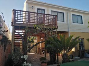 a house with a wooden deck in front of it at The Wee Hoose in Strand