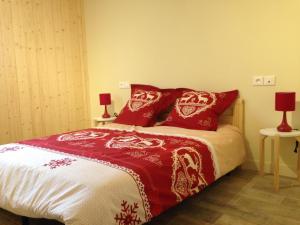 a bedroom with a bed with red pillows at Le chalet des Patures in Rochefort-Montagne