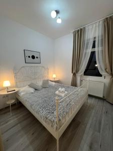 ein Schlafzimmer mit einem weißen Bett und einem Fenster in der Unterkunft Apart City Center in Braşov