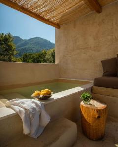 una vasca da bagno con un cesto di frutta seduto sopra di Meli Suites Isle - Adults Only a Skala Potamias