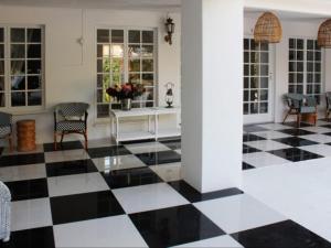 una camera con pavimento a scacchi in bianco e nero di La Belle Guest House a Bloemfontein