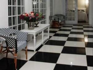 a living room with a black and white checkered floor at La Belle Guest House in Bloemfontein