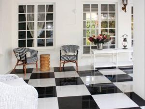 ein Wohnzimmer mit einem schwarz-weiß karierten Boden in der Unterkunft La Belle Guest House in Bloemfontein