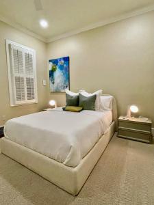 um quarto com uma grande cama branca e 2 candeeiros em Elegance & Charm 27 Steps To Old Christ Church em Pensacola