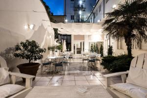 a courtyard with tables and chairs in a building at Hotel London in Viareggio