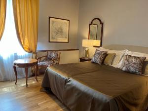 a bedroom with a bed and a table and a chair at Hotel Villani in Florence